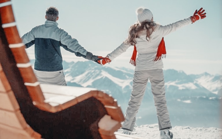 Paar hält Hände und schaut in die Bergwelt