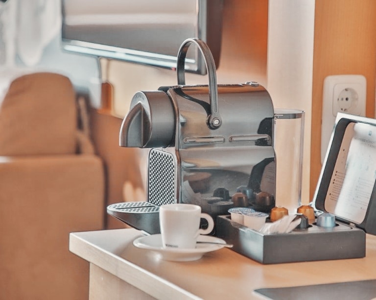 Kaffeemaschine auf Sideboard mit Tasse und Kapseln